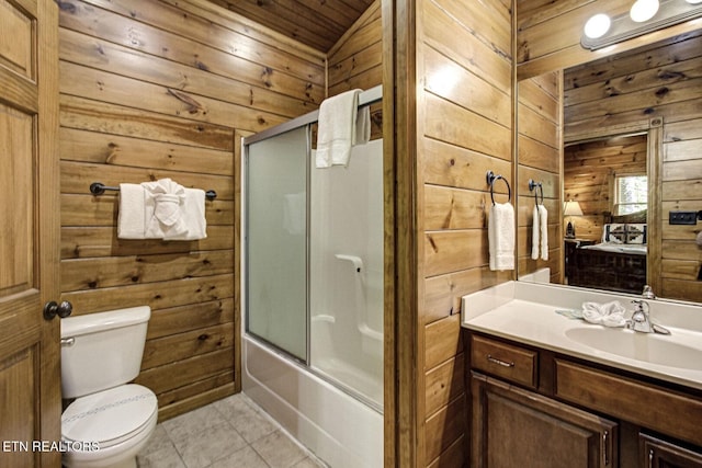 full bathroom with wood walls, toilet, vanity, tile patterned flooring, and shower / bath combination with glass door