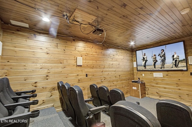 carpeted home theater room featuring wood walls and wood ceiling