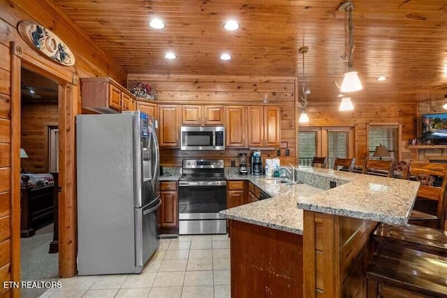 kitchen featuring a peninsula, a breakfast bar, stainless steel appliances, wooden ceiling, and light tile patterned flooring