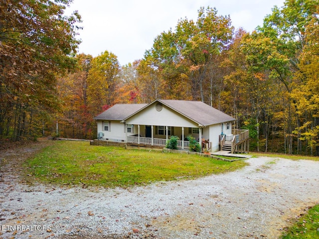 1149 Panther Branch Rd, Jamestown, TN 38556 - view of front of property with a porch, gravel driveway, a wooded view, and a front lawn
