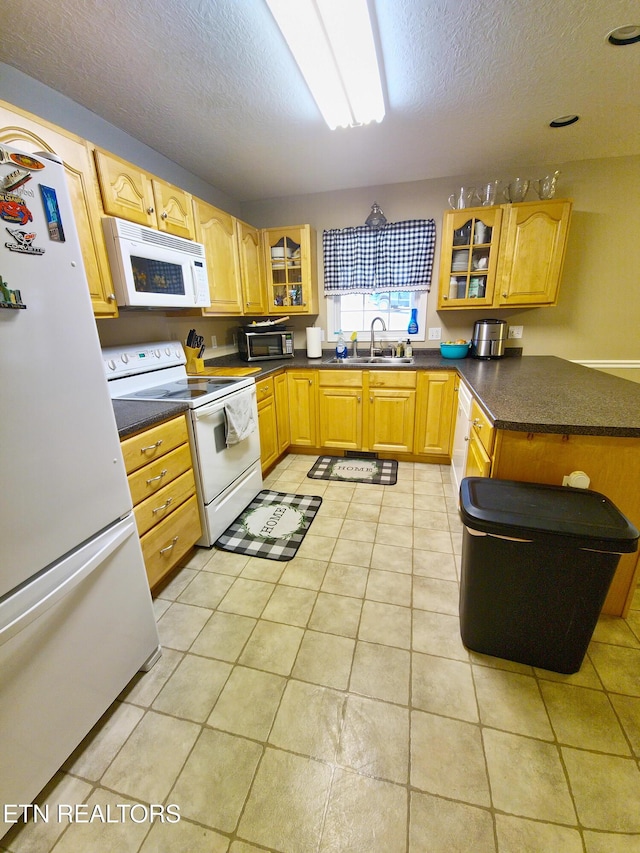 kitchen with a textured ceiling, white appliances, sink, and light tile patterned floors