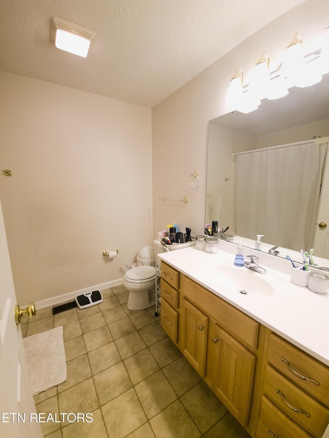 bathroom with tile patterned floors, vanity, and toilet