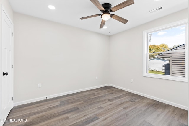empty room featuring wood finished floors, a ceiling fan, visible vents, baseboards, and recessed lighting