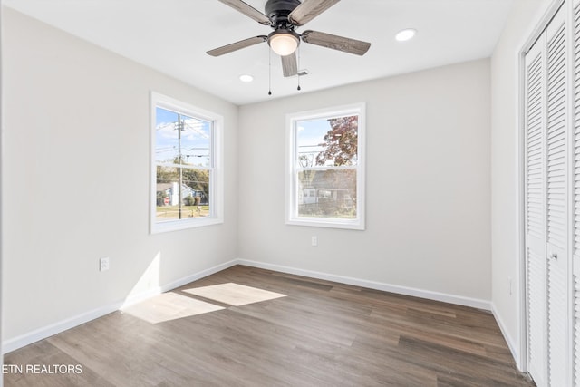 unfurnished bedroom featuring a closet, wood finished floors, baseboards, and recessed lighting