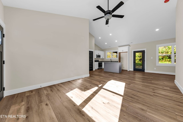 unfurnished living room with light hardwood / wood-style floors, high vaulted ceiling, and ceiling fan