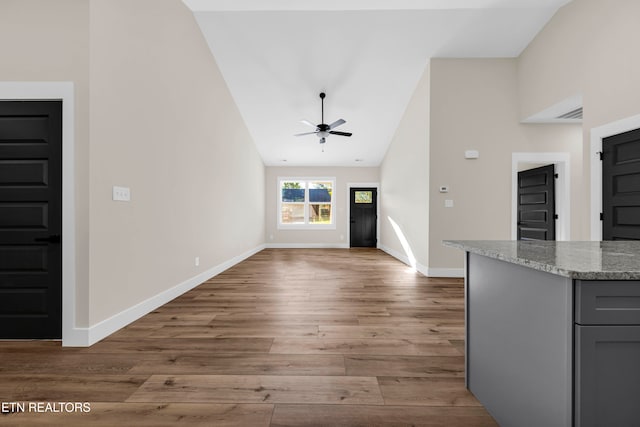 unfurnished living room featuring light hardwood / wood-style flooring, high vaulted ceiling, and ceiling fan