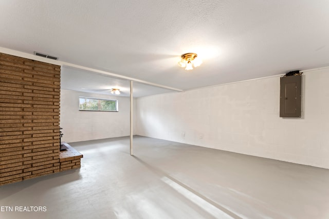 basement with a fireplace, electric panel, and a textured ceiling