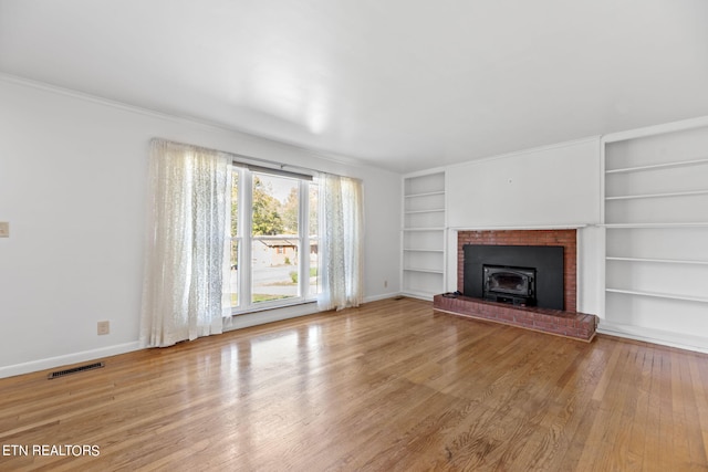 unfurnished living room with built in features and light wood-type flooring