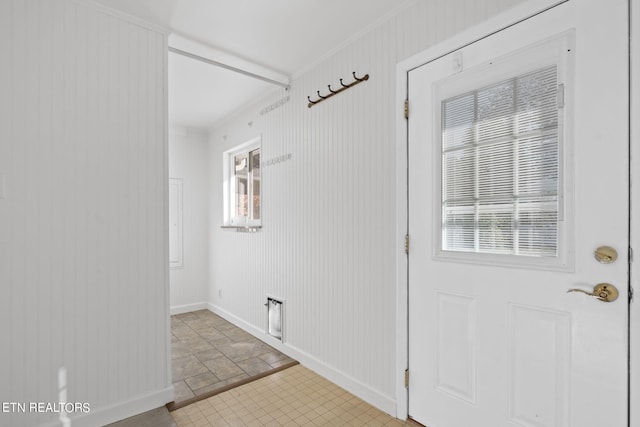 interior space with a wealth of natural light, ornamental molding, and wood walls