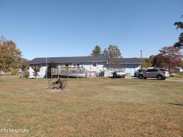 view of front facade with a wooden deck, a front lawn, and a garage