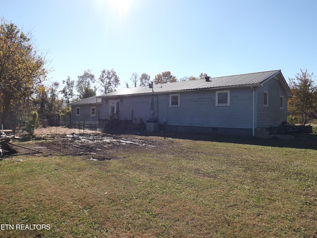 rear view of house featuring a yard