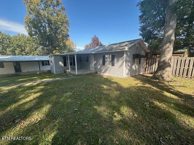 back of property with a patio area and a yard