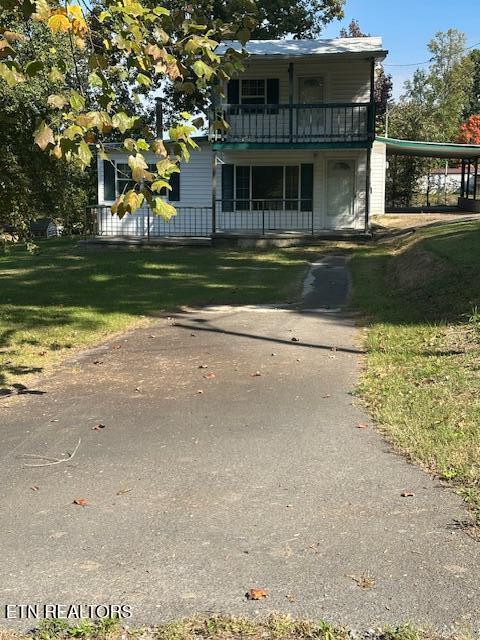 view of front property featuring a front lawn and a carport