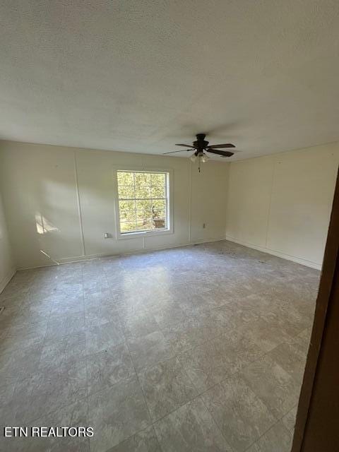 empty room with ceiling fan and a textured ceiling