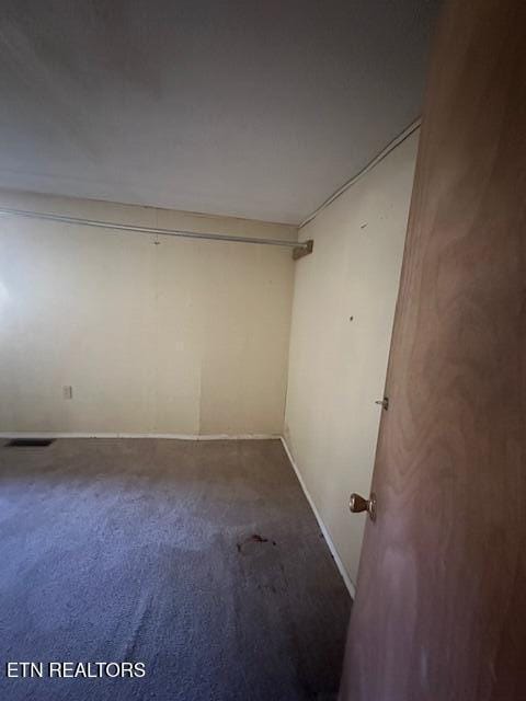 empty room with dark colored carpet