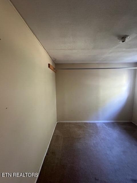 carpeted empty room featuring a textured ceiling