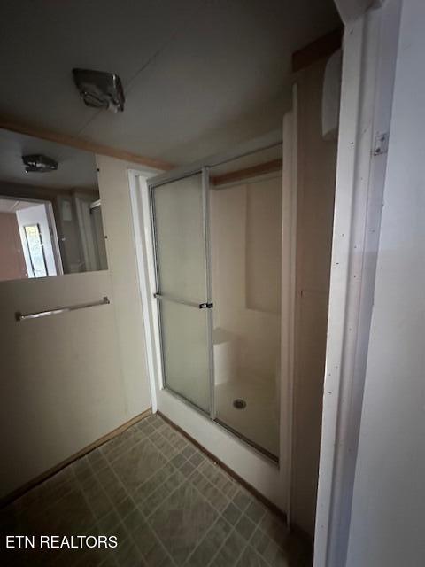 bathroom with a shower with door