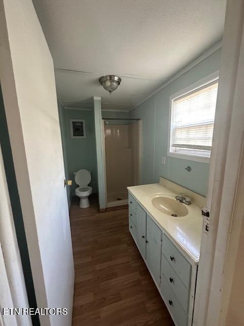 bathroom with a shower, wood-type flooring, toilet, and vanity