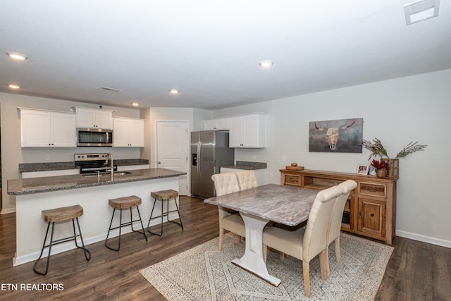 dining room featuring sink and dark hardwood / wood-style flooring