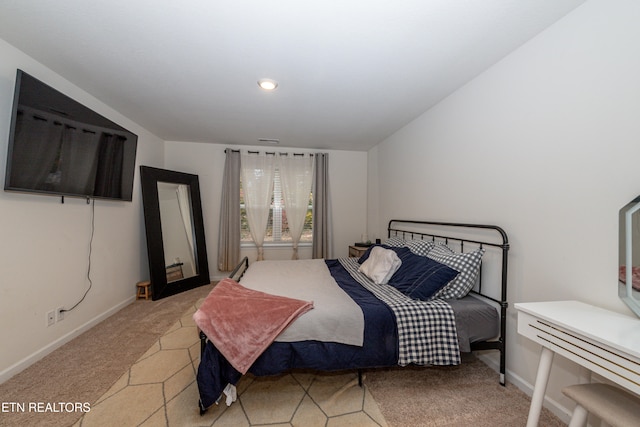 bedroom with light carpet and baseboards