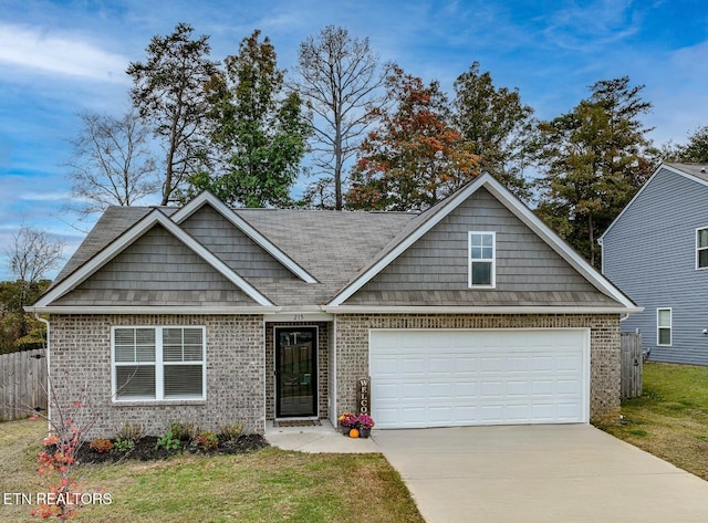 view of front of property featuring brick siding, a front yard, fence, a garage, and driveway