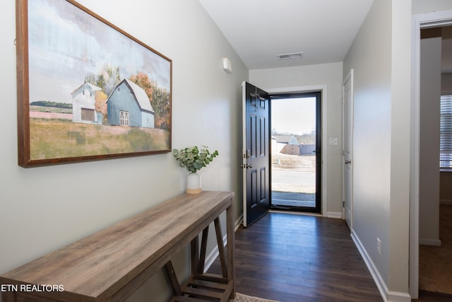 doorway featuring baseboards, visible vents, and dark wood-style flooring