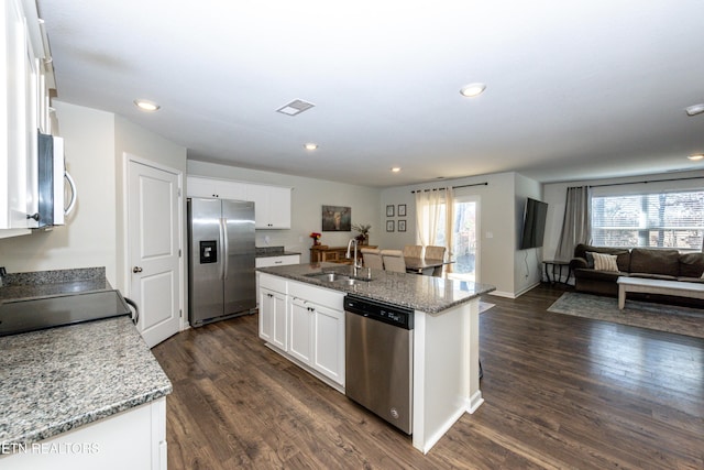 kitchen with a center island with sink, appliances with stainless steel finishes, white cabinets, and a sink