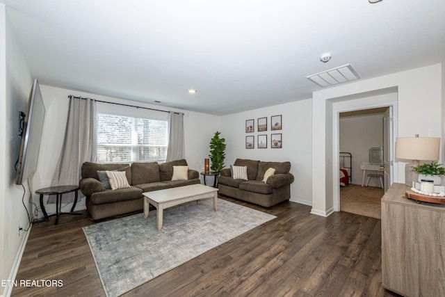 living area with dark wood-style floors, visible vents, and baseboards