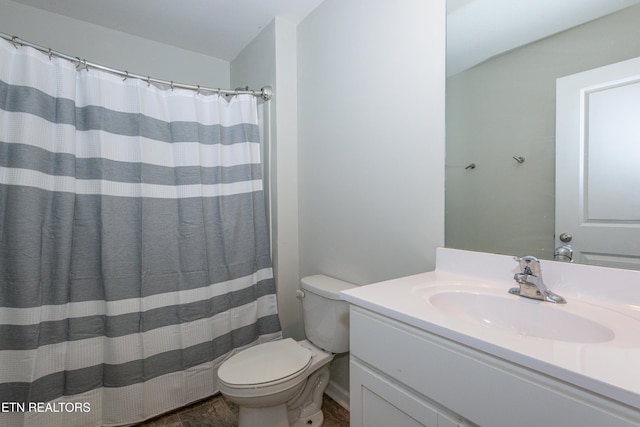 bathroom featuring curtained shower, vanity, and toilet