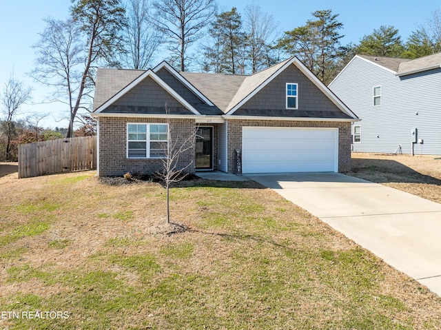 view of front of property with brick siding, a front lawn, an attached garage, and fence