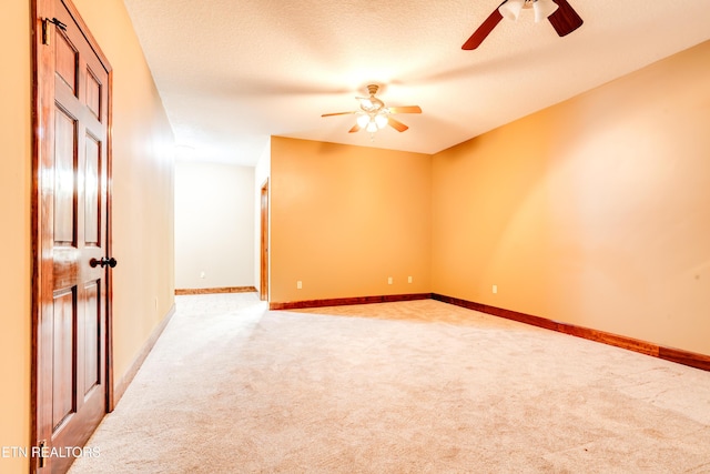 carpeted empty room featuring a textured ceiling and ceiling fan