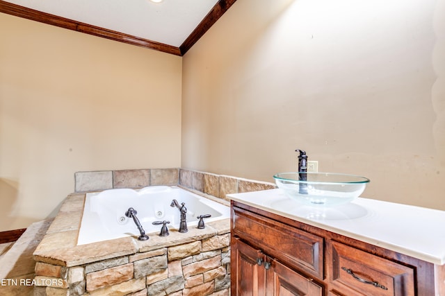 bathroom with ornamental molding, tiled bath, and vanity