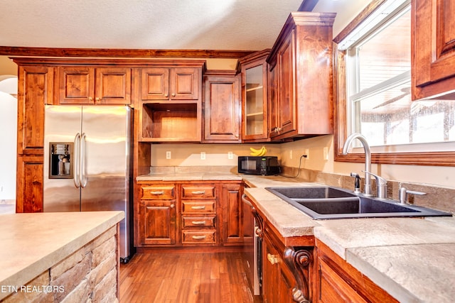 kitchen featuring stainless steel fridge with ice dispenser, light hardwood / wood-style flooring, sink, and a textured ceiling