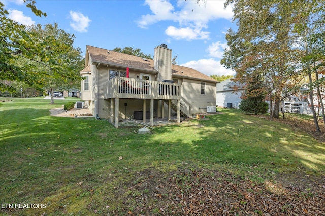 back of house featuring a deck, a lawn, and central AC unit