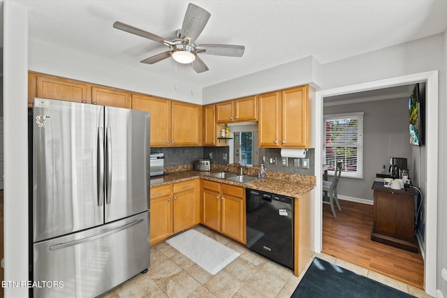 kitchen with black dishwasher, tasteful backsplash, ceiling fan, light stone counters, and stainless steel refrigerator