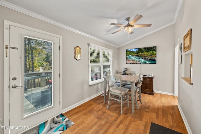 dining area featuring crown molding, lofted ceiling, light wood-type flooring, and ceiling fan