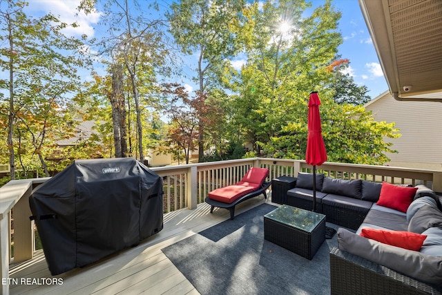 wooden terrace with an outdoor hangout area and grilling area