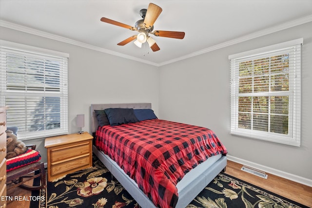 bedroom featuring ornamental molding, wood-type flooring, and ceiling fan