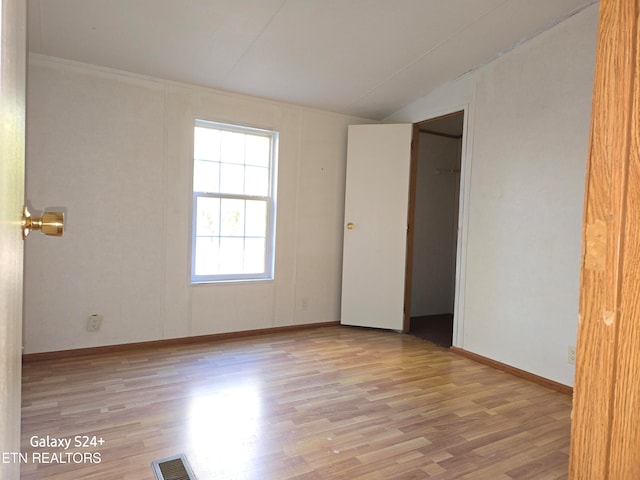 empty room featuring light hardwood / wood-style flooring and lofted ceiling