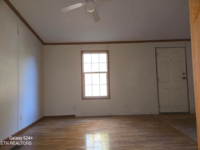 spare room with ceiling fan, hardwood / wood-style flooring, ornamental molding, and vaulted ceiling