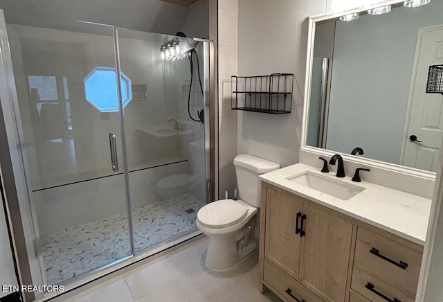 bathroom with vanity, toilet, tile patterned flooring, and a shower with door