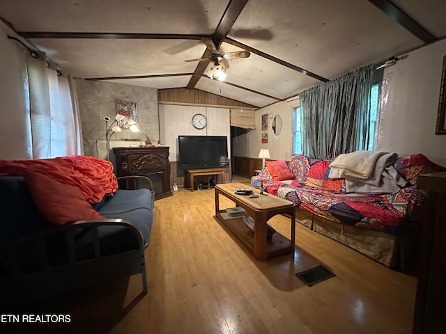 living room featuring light hardwood / wood-style flooring, lofted ceiling with beams, and ceiling fan