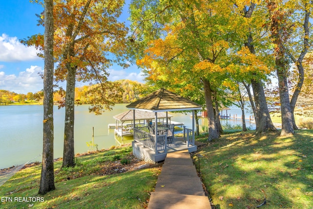 view of dock featuring a gazebo, a yard, and a water view