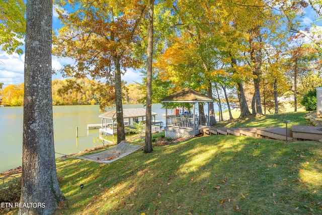 dock area with a water view and a yard