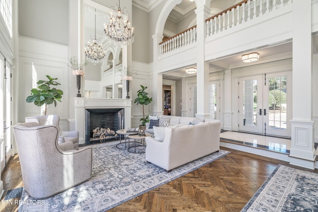 living room featuring a high ceiling, crown molding, dark parquet flooring, and french doors