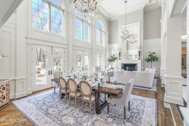 dining area featuring a towering ceiling, ornamental molding, a healthy amount of sunlight, and dark hardwood / wood-style floors