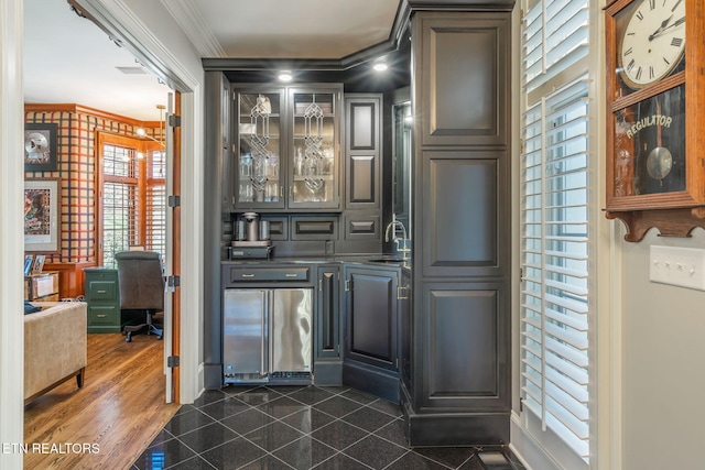 bar with sink, crown molding, stainless steel refrigerator, and dark hardwood / wood-style flooring