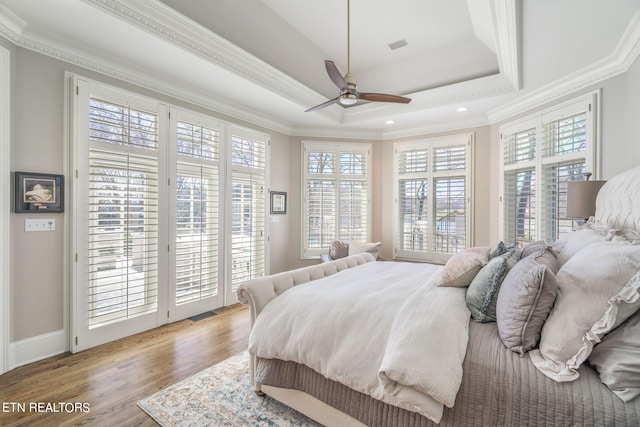 bedroom with access to outside, a tray ceiling, light hardwood / wood-style floors, ceiling fan, and ornamental molding