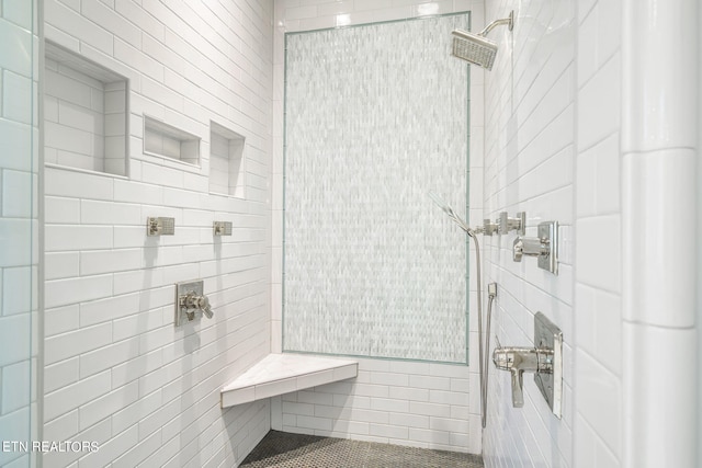 bathroom with tile walls and tiled shower