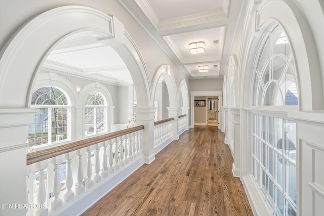 corridor with coffered ceiling, ornamental molding, beamed ceiling, and hardwood / wood-style floors